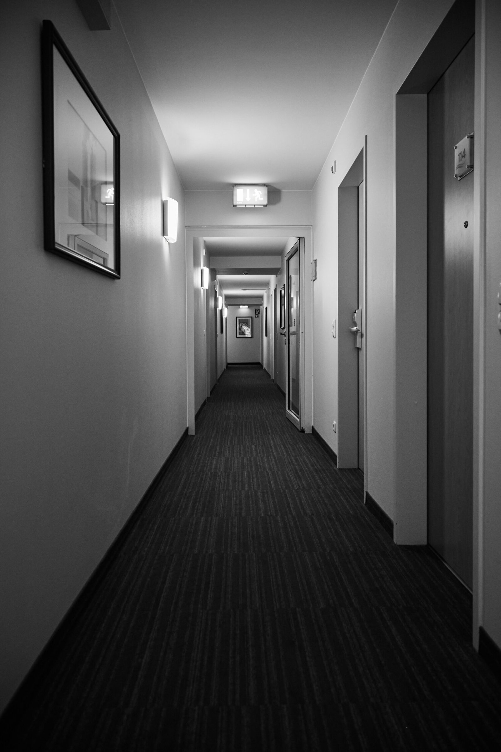 grayscale photo of hallway with doors